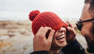 Γυναίκα με σακίδιο πλάτης χαμογελά καθώς περπατάει με φίλο στην εξοχή